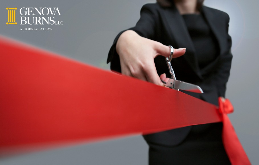 Close up of businesswoman cutting red ribbon